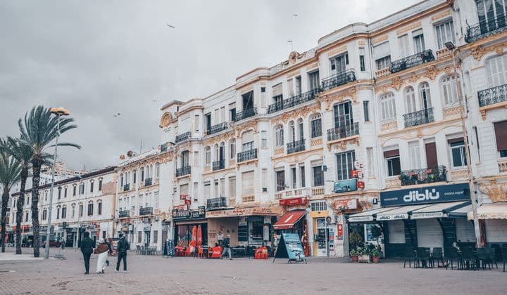 Elegant colonial buildings line a bustling city square in Tangier, Morocco.